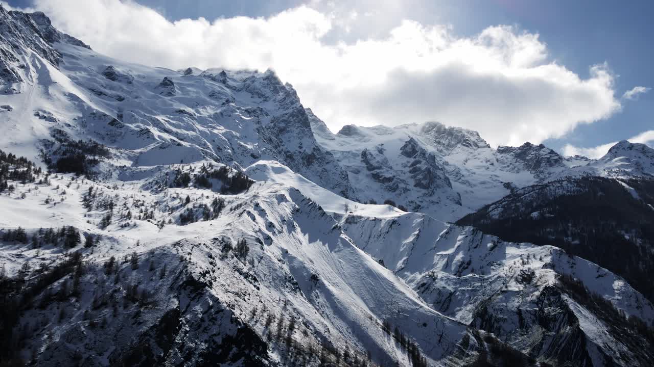 A breathtaking aerial view of snow-covered mountain peaks, showcasing serene alpine landscapes and crisp natural beauty during winter
