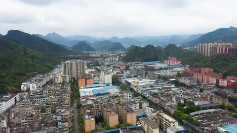 wide aerial view of a small town in the famous guizhou province with iconic hills in the background. china