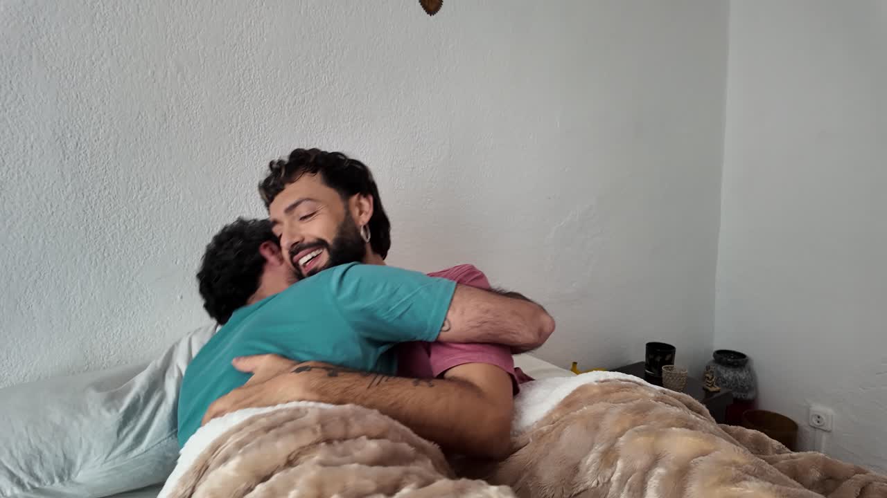 Gay couple embracing in bed