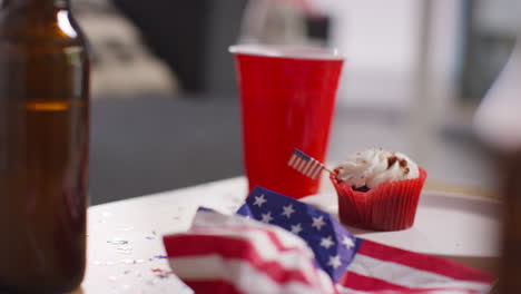 Primer-Plano-De-Cupcakes,-Banderas-Estadounidenses-Con-Estrellas-Y-Rayas-Y-Botellas-De-Cerveza-En-Una-Fiesta-Que-Celebra-El-4-De-Julio,-Día-De-La-Independencia.