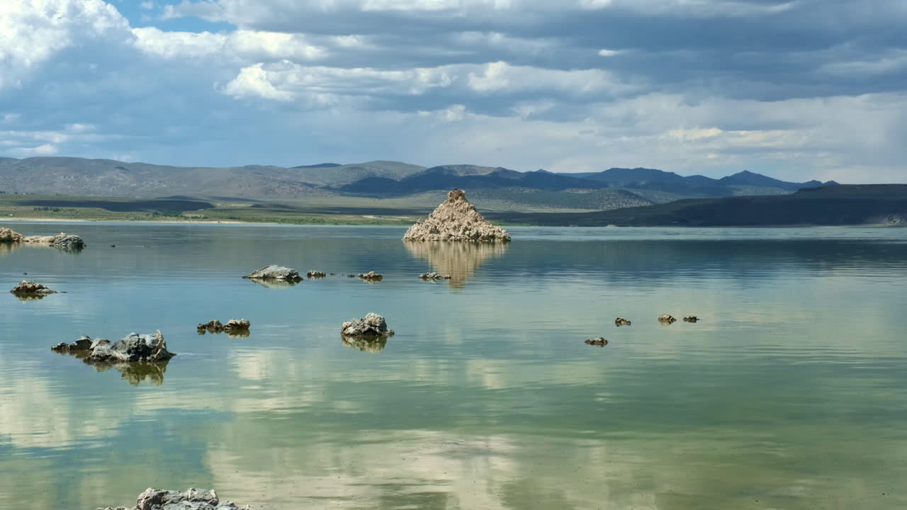 구름이 반사되고 산이 배경에 있는 석회암 석회암이 특징인 유리하고 매끄러운 캘리포니아 모노호의 넓은 풍경 사진