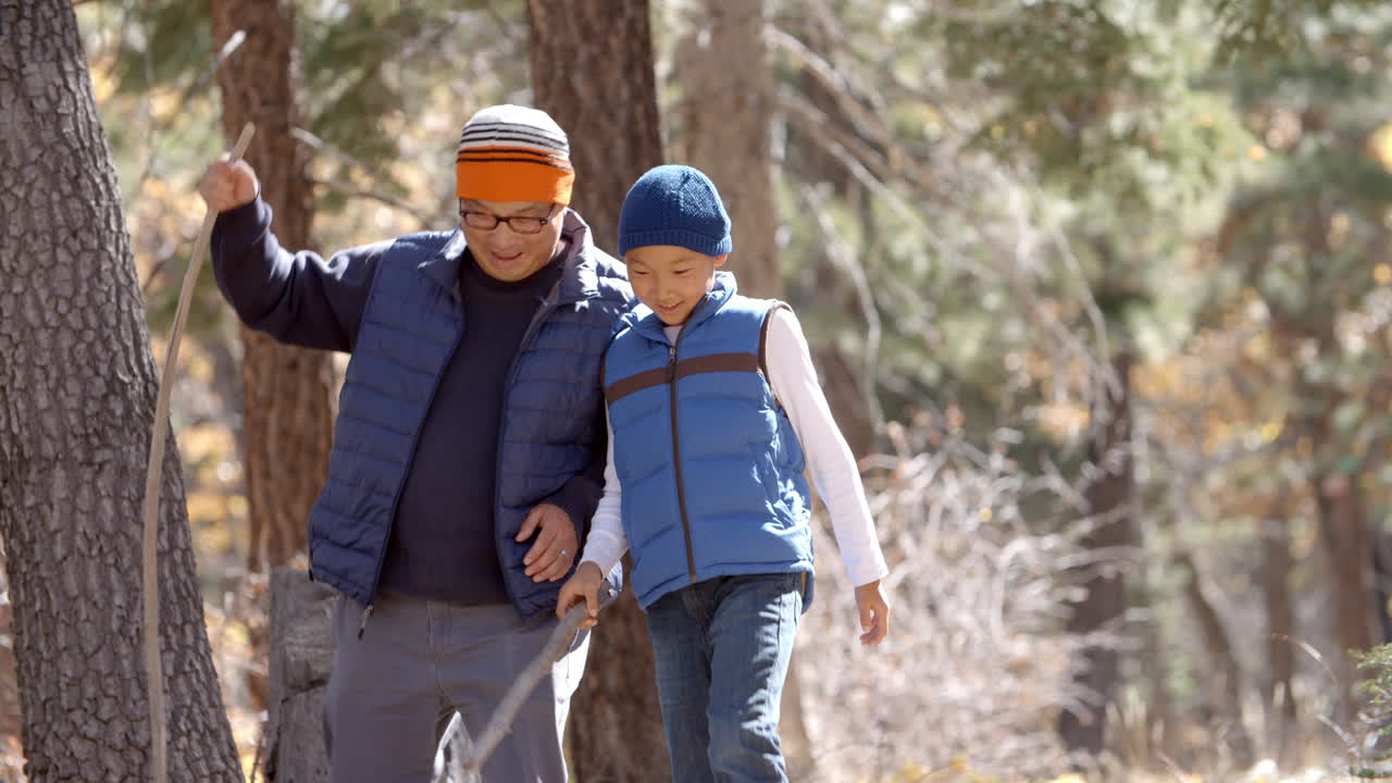 padre y hijo asiáticos caminando juntos en un bosque