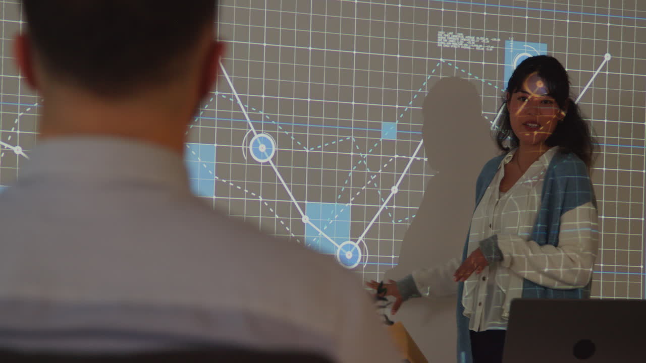 maestra dando lecciones de matemáticas o ciencias en una universidad o universidad de pie en la parte delantera de la clase con una proyección de gráfico