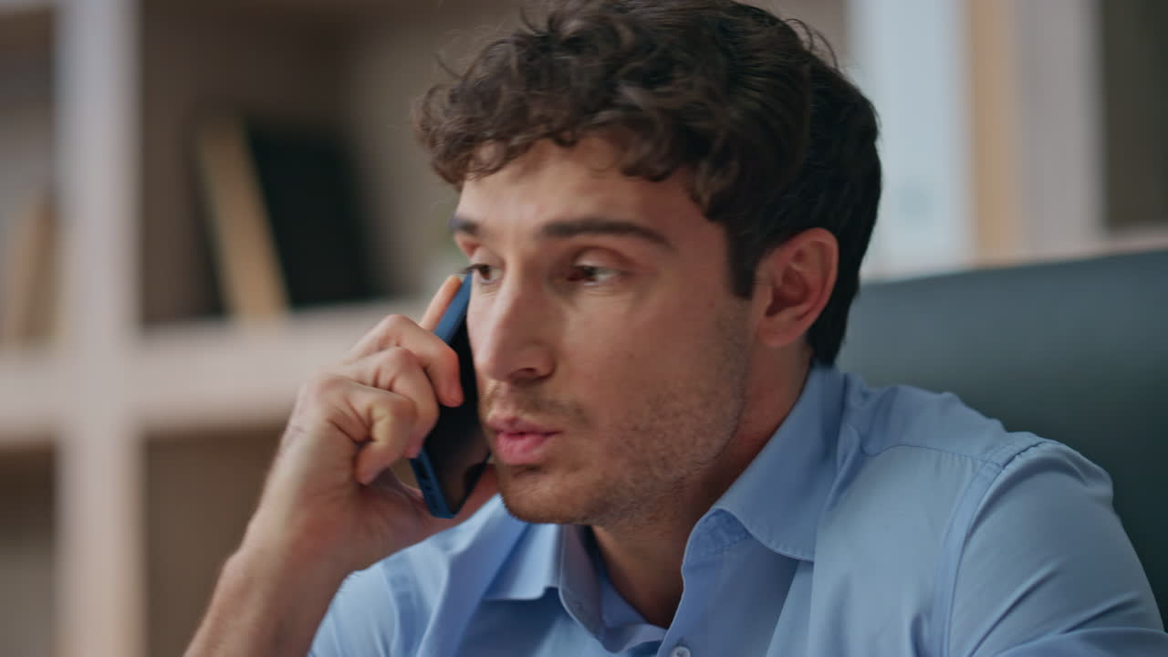 Frustrated guy calling smartphone in home office closeup. Unhappy customer solve