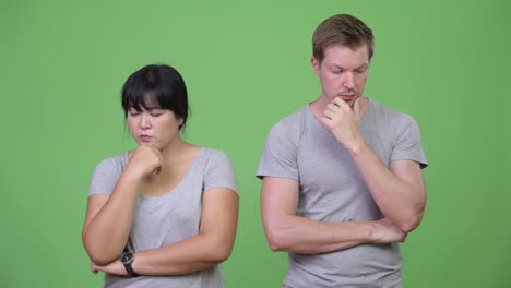 young sad multi-ethnic couple thinking together