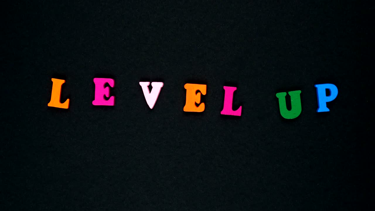 la palabra "nivel arriba" está formada por letras de madera multicolores. palabras coloridas en bucle.