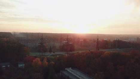 view of the site with high-voltage lines on the background of the road and trees at sunset. camera motion forward. aerial view