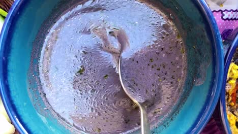 close-up-view-of-traditional-blue-clay-bowl-and-rare-delicious-purple-color-traditional-food-oil-bubble-organic-qurut-kasht-tasty-cuisine-gourmet-meal-dairy-dry-mint-fresh-garlic-tomato-eggplant-Iran