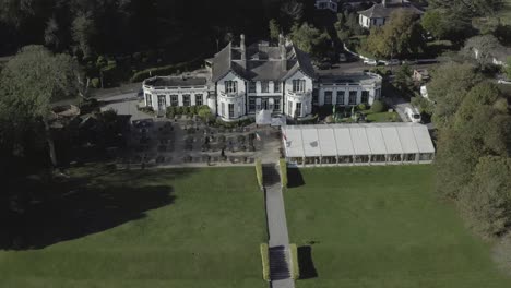 retreating aerial of elegant haven hotel and extensive grounds, irl