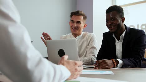 los trabajadores de oficina modernos sentados en una computadora portátil resuelven tareas creativas para crear nuevos productos comerciales. grupos multiétnicos de hombres y mujeres
