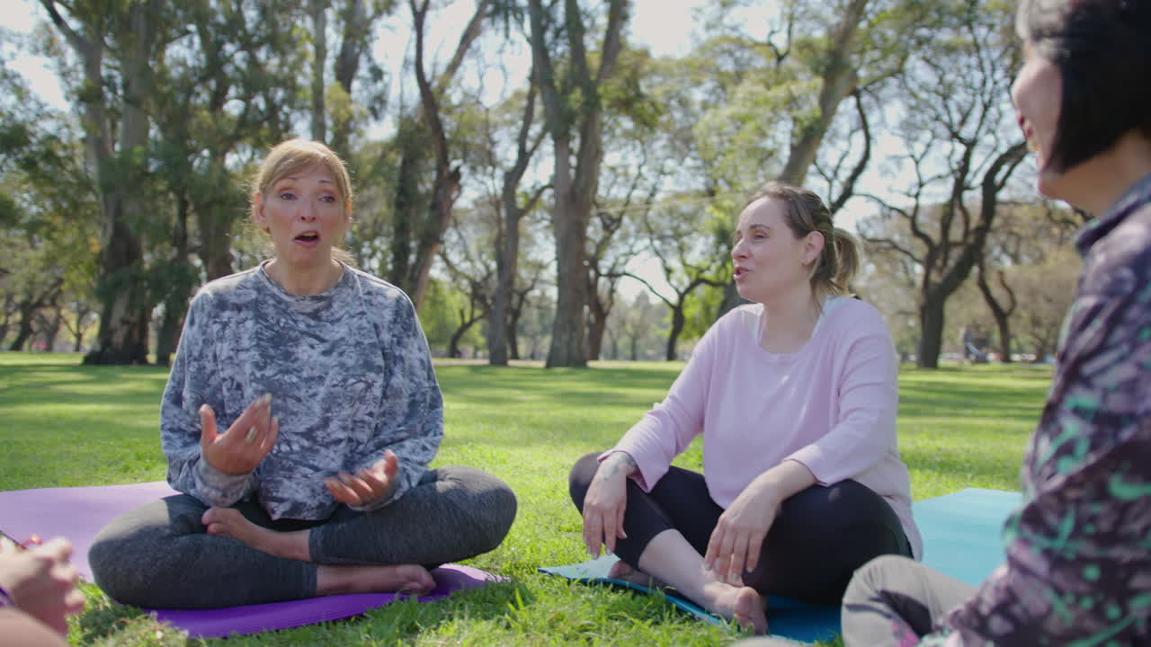 Women friends enjoying a yoga session in a park