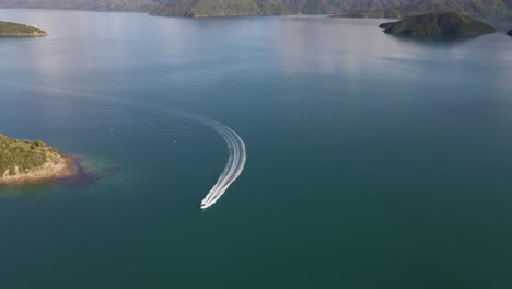 fast speed boat making a turn around a peninsula in morning sunlight