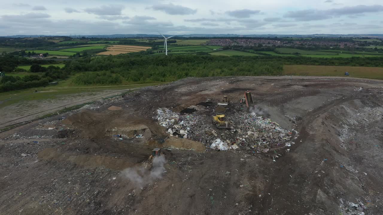 Bulldozers plough human rubbish into landfill sites in the countryside