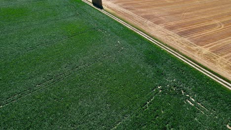 Fardos-De-Heno-Apilados-Al-Lado-De-La-Carretera-Rural-Vacía,-Vista-De-Drones