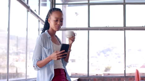 African-american-casual-businesswoman-using-smartphone-in-office,-slow-motion,-copy-space