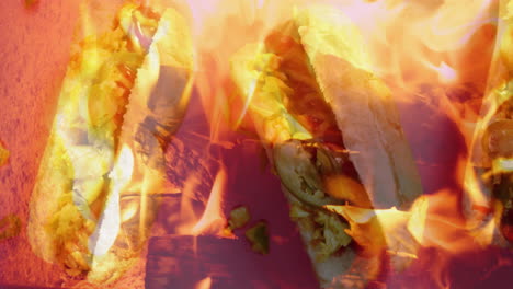 grilling sandwiches with vegetables and cheese over open flames in backyard