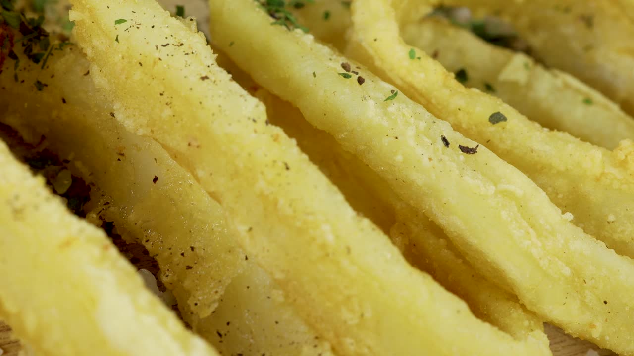 tiro macro de agregar sal a los anillos de calamar fritos crujientes