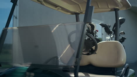 empty golf cart equipment at country fairway. clubs bag in golfing car outside.