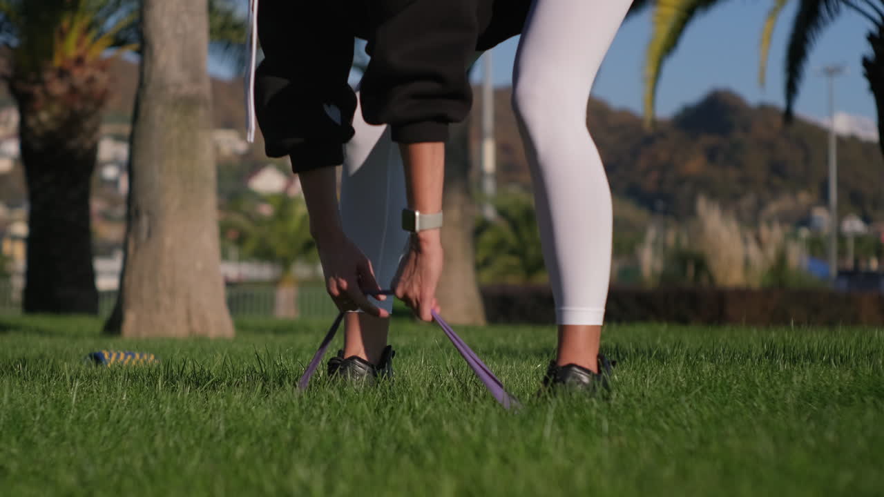 야외에서 저항 밴드로 운동하는 여성