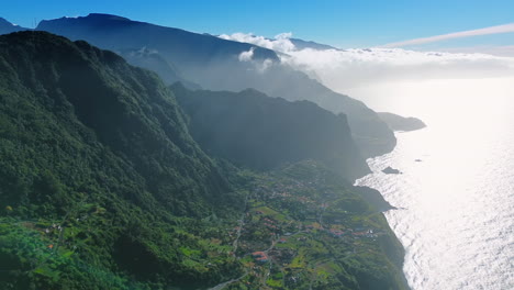 spectacular view of the town located at the atlantic ocean shore near the green mountain. drone footage above the hazy scenery of madeira, portugal.