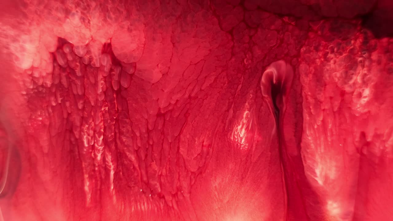 красная чернила, распространяющаяся в воде, напоминающая органическую ткань или потоки лавы, макро крупный план
