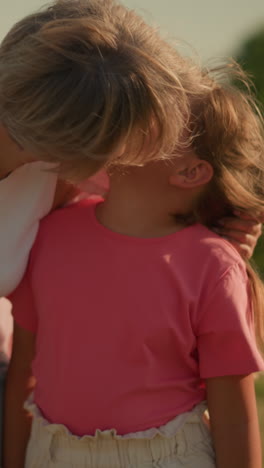 madre e hija caminando felices en el campo abierto con la madre sonriendo mientras besa suavemente a la hija en la mejilla, la madre con un ramo de flores en la mano, disfrutando del día soleado