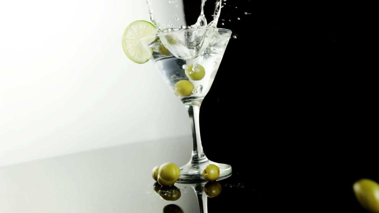 Animazione di forme viola sopra una bevanda con olive e lime su sfondo bianco e nero.
