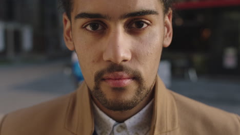 close up portrait of young mixed race businessman looking up slow motion confident pensive in city