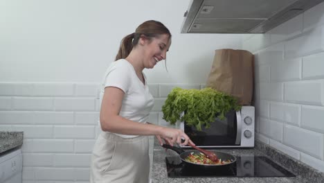 woman cooking stir-fry in a kitchen