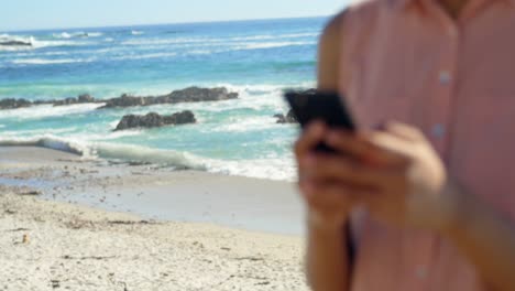 primer plano de una mujer escribiendo un mensaje de texto en la playa 4k