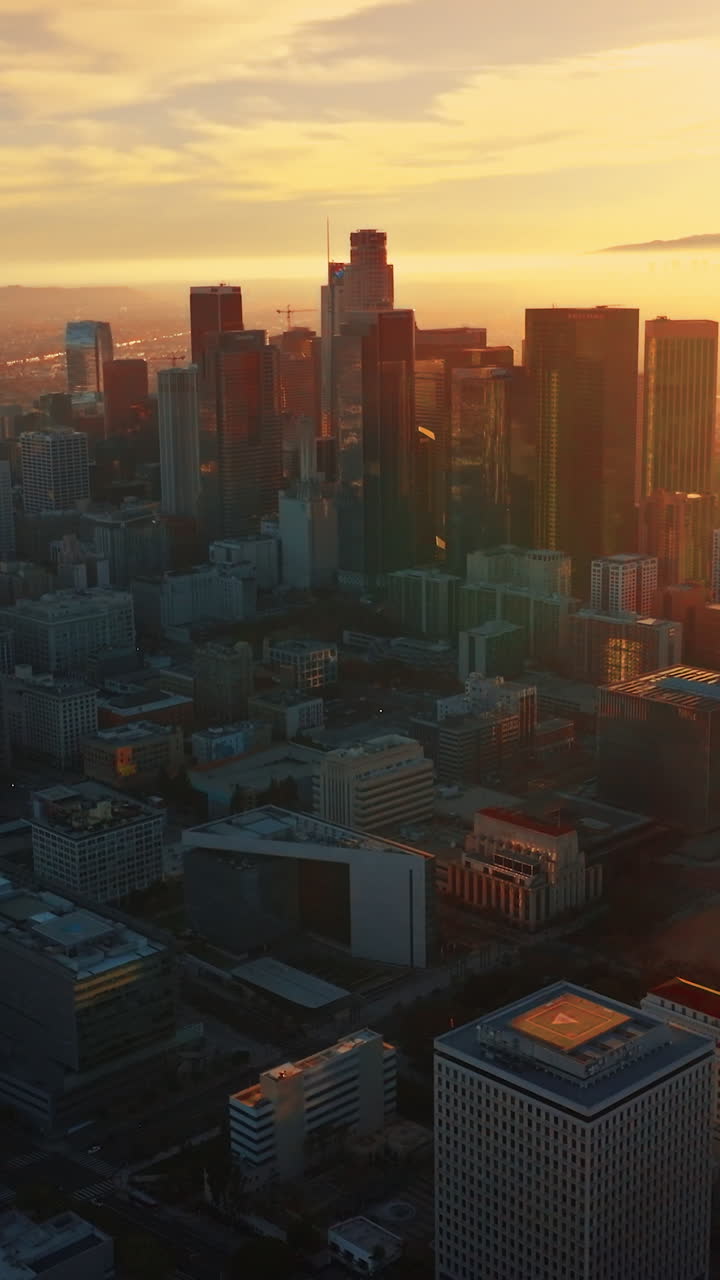 Immense scenery of stunning Los Angeles at sunset. Downtown with skyscrapers from aerial perspective. Vertical video