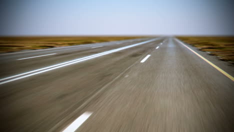 Animación-De-Carretera-Sin-Fin-Desde-La-Posición-Delantera-Del-Automóvil.-Un-Paseo-Por-Un-área-Natural-En-Algún-Lugar-Del-Sur-De-Los-Estados-Unidos-De-América-O-El-Norte-De-México.-Cielo-Azul-Sin-Nubes.-En-Bucle.-HD