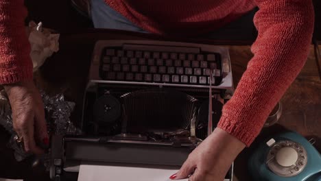 author woman loads typewriter then crumples paper and picks up whiskey and cigar