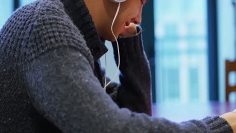 Man-listening-to-music-with-headphone-and-digital-tablet