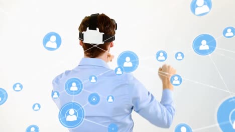 Animation-of-network-of-connections-with-people-icons-over-businessman-wearing-vr-headset