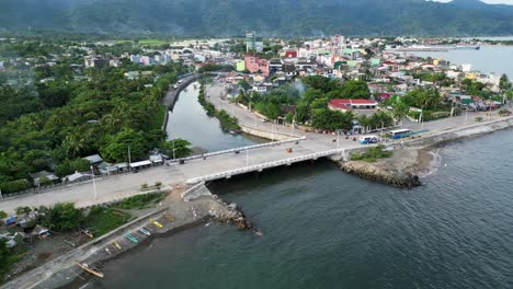 panoramic aerial view of a lush, coastal philippine town with a bridge and estuary in tropical island of catanduanes