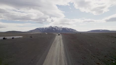 Coche-Conduciendo-Hacia-Una-Montaña-Nevada-En-Islandia