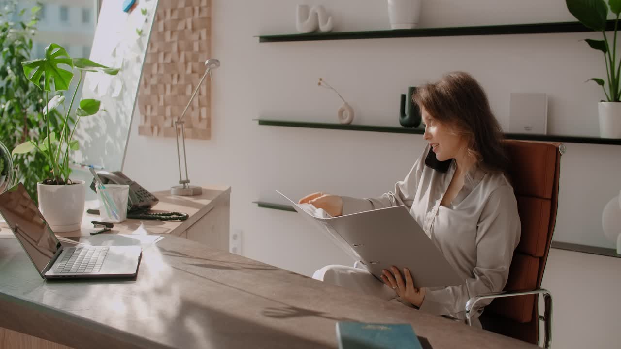 Žena pracující z domova na notebooku a telefonu