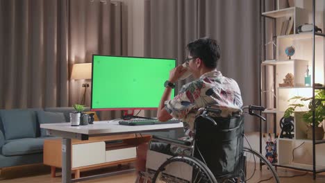 녹색 화면 모니터와 함께 집에서 일하는 체어에 앉은 사람