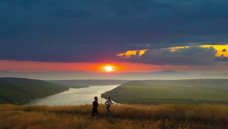 the man and woman run along the mountain on scenic river background. slow motion