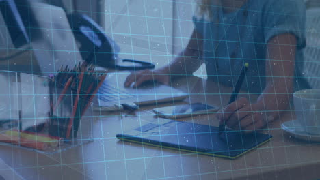 animation of biometric over hands of caucasian businesswoman using laptop and graphics tablet
