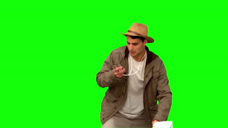 Man-with-a-map-and-a-compass-orienteering-on-green-screen