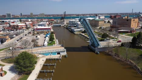 Barco-En-El-Río-Con-Puente-Levadizo-Abierto-En-El-Río-Negro-En-Port-Huron,-Michigan-Con-Video-De-Drones-Avanzando