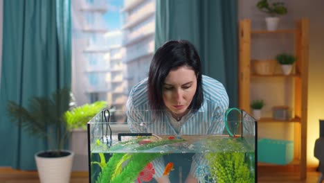 young woman with a smartphone googling information about aquarium fish