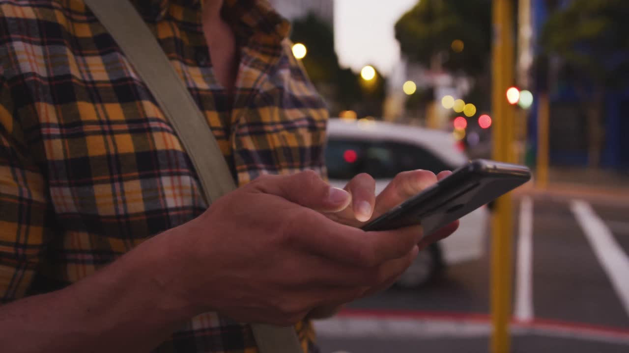 Caucasian male using his tablet in a street in the evening