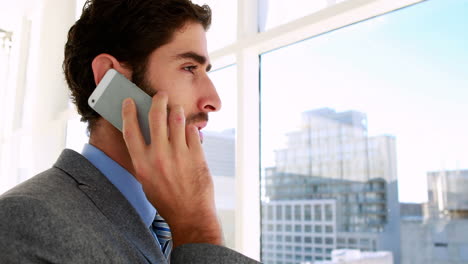 un hombre de negocios guapo hablando por teléfono.