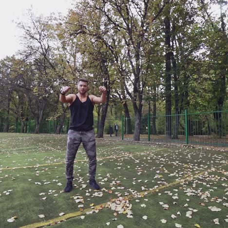 handsome bearded sportsman outdoors. muscular athlete doing exercises in the open air in autumn. slow motion.