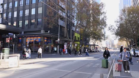 pedestrians crossing a busy street in melbourne