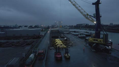 Descargador-De-Barcos-Y-Carretillas-Elevadoras-En-La-Terminal-Con-Personas-Que-Trabajan-De-Noche