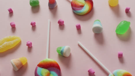 video of colourful various sweets on pink background